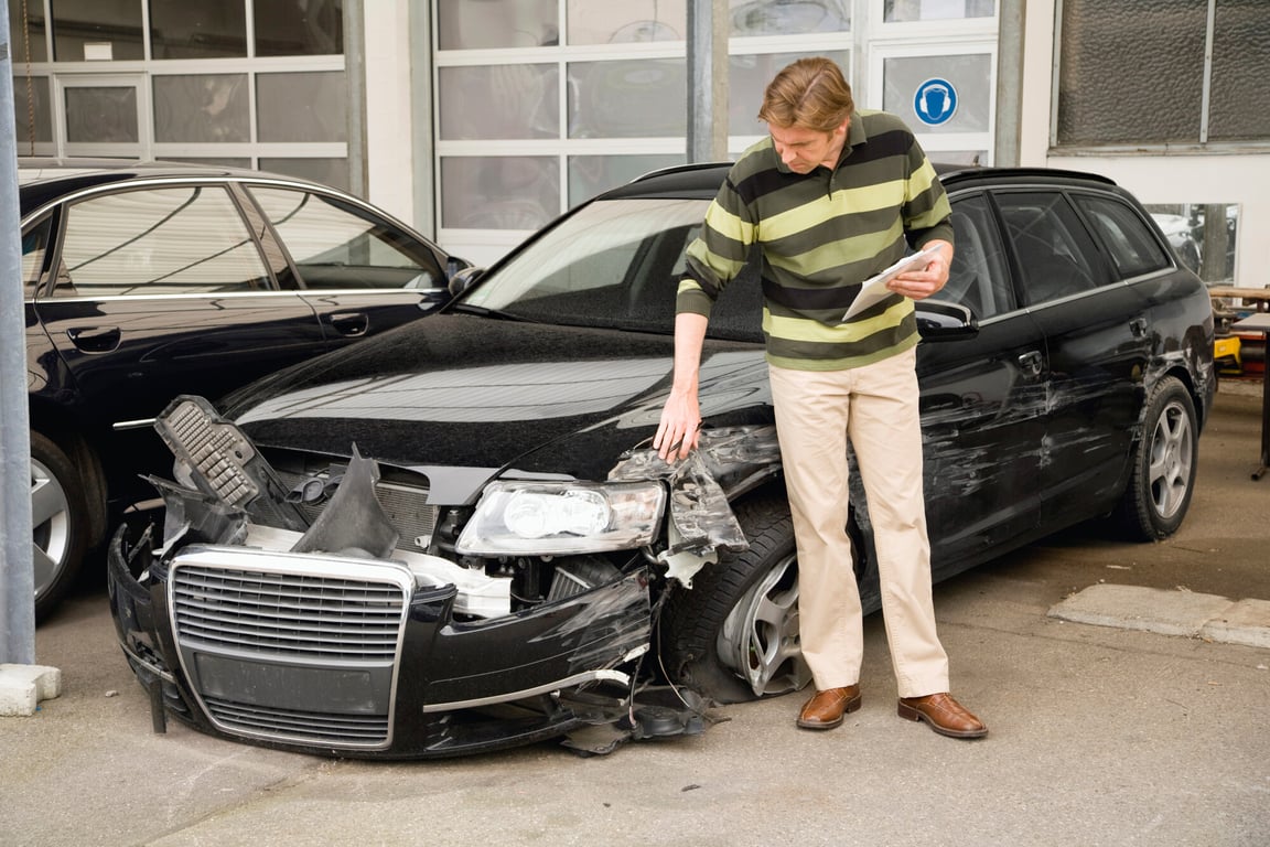 Man inspecting a car that was in an accident